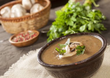 Maydanozlu lezzetli kremalı mantar çorbası ve koyu bir arka planda yakın plan..