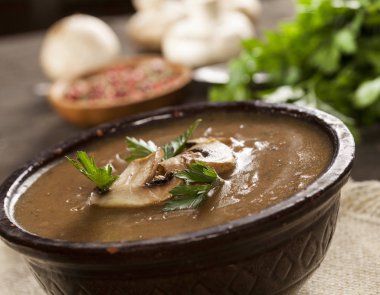 Maydanozlu lezzetli kremalı mantar çorbası ve koyu bir arka planda yakın plan..