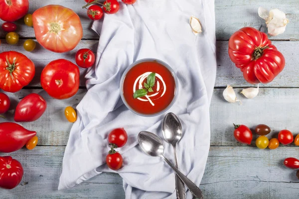 Traditionele Spaanse koude tomaat soep gazpacho in een kom over blauwe houten achtergrond. — Stockfoto