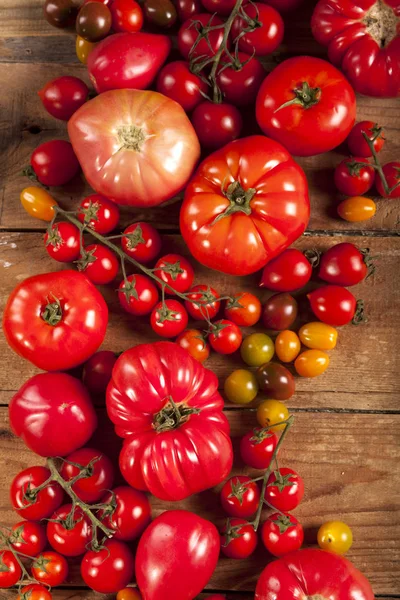 Tomaten op rustieke houten achtergrond bovenaanzicht — Stockfoto