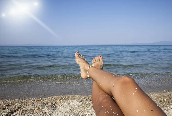 한 여성 이 해변에서 다리에 불을 질렀습니다. 여행 컨셉이야. 열 대의 낙원에서 행복 한 발. — 스톡 사진