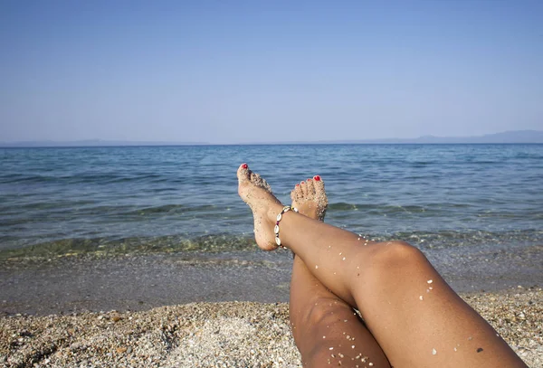 砂のビーチで足を日焼け女性。旅行のコンセプト。熱帯の楽園で幸せな足. — ストック写真