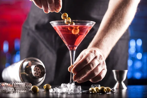 Barman faz coquetel cosmopolita em um bar — Fotografia de Stock