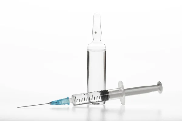 Ampola de medicina de vidro e seringa no fundo branco — Fotografia de Stock