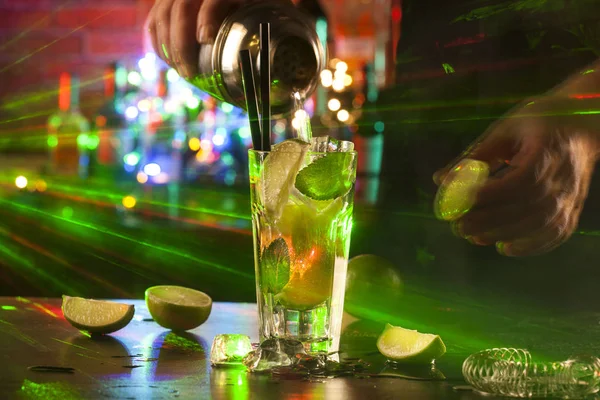 Zbliżenie barmana robiącego koktajl mojito na tle świateł w barze. Składniki i naczynia. — Zdjęcie stockowe