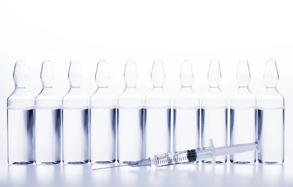 Glazen medicijnampullen en spuiten op witte achtergrond — Stockfoto