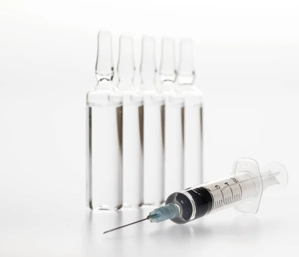 Medizinische Ampullen und Spritze aus Glas auf weißem Hintergrund — Stockfoto