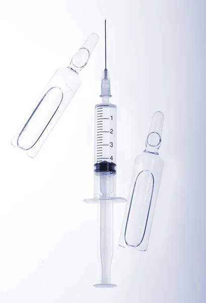 Ampolas de medicina de vidro e seringa no fundo branco — Fotografia de Stock