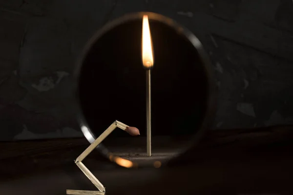 Broken match is against the mirror and the reflection shows a whole standing burning stick — Stock Photo, Image