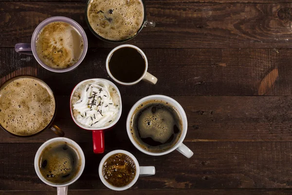 Mucha café en diferentes tazas en la mesa de madera. — Foto de Stock