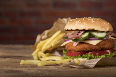 Tahta masada taze burger ve tuğla duvar arka planında