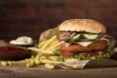 Tahta masada taze burger ve tuğla duvar arka planında