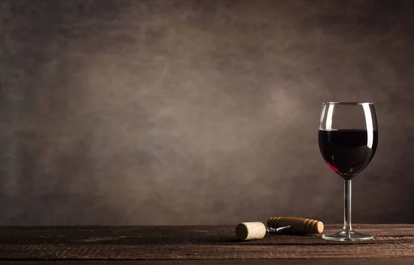 Vino tinto en vidrio en un fondo oscuro con espacio de copia. — Foto de Stock