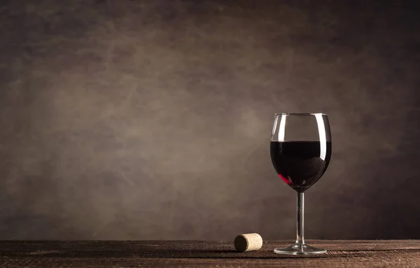 Rotwein im Glas auf dunklem Hintergrund mit Kopierraum — Stockfoto