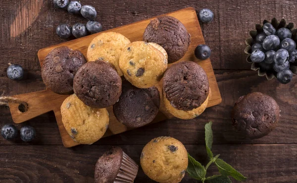Borůvkové a čokoládové muffiny na dřevěném pozadí — Stock fotografie