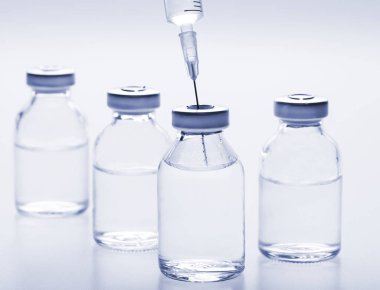 Cam ilaç şişeleri ve beyaz arka planda şırınga