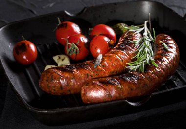 Tavada ızgara sosis ve siyah arkaplan