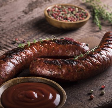 Tahta ve ahşap arka planda ızgara sosisler.