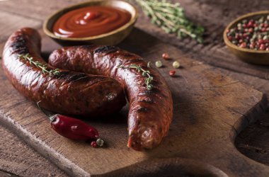 Tahta ve ahşap arka planda ızgara sosisler.