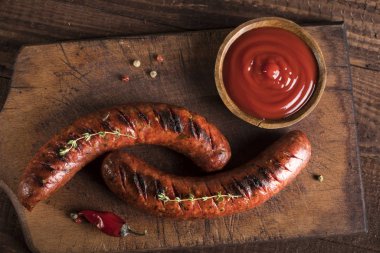 Tahta ve ahşap arka planda ızgara sosisler.