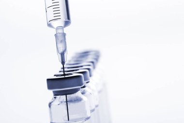 Cam ilaç şişeleri ve beyaz arka planda şırınga