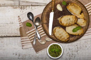 Köfte ve fesleğenle dilimlenmiş geleneksel tost ekmeği kesme tahtası ve beyaz masa