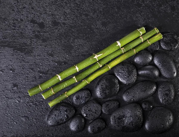 Bambu pinnar med svarta zen stenar på en svart bakgrund. Spakoncept — Stockfoto