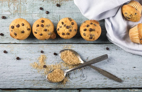 Čokoládová vanilka čerstvé lahodné muffiny na modrém dřevěném pozadí. Horní pohled — Stock fotografie