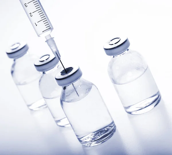 Frascos de medicamentos de vidro e seringa sobre fundo branco — Fotografia de Stock