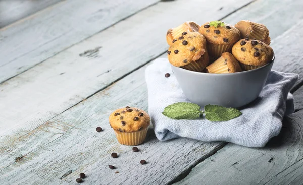 Čokoládová vanilka čerstvé lahodné muffiny na modrém dřevěném pozadí — Stock fotografie