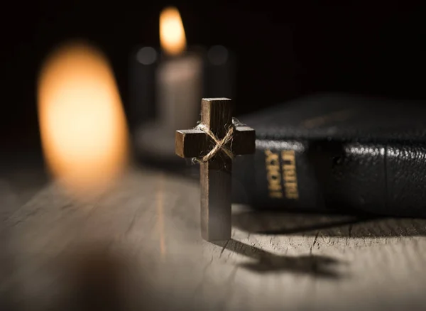 Bíblia Sagrada e cruz de madeira no fundo escuro — Fotografia de Stock