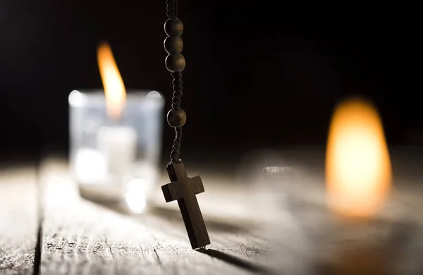 Rosario Perline e candele su sfondo di legno — Foto Stock