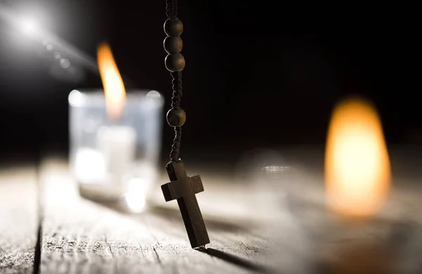 Rosario Perline e candele su sfondo di legno — Foto Stock