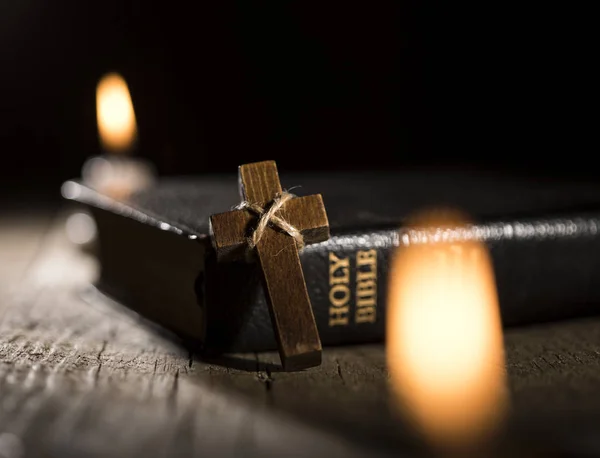 Święta Biblia i drewniany krzyż na ciemnym tle — Zdjęcie stockowe