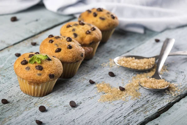 Schokolade Vanille frische leckere Muffins auf blauem Holzhintergrund Stockbild