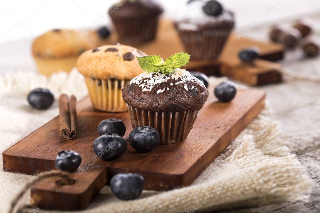 Blueberry and chocolate muffins on white wooden background