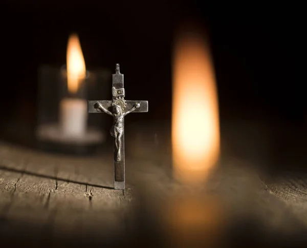 Металевий хрест і свічки на темному фоні — стокове фото