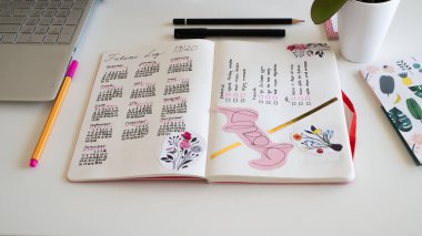 Günlük yaşam biçimi, Bullet Journal - Planer - Notebook - beyaz arkaplan, orkide, kalem, yapışkan notlar üzerine düzenlenmiş çatal bıçaklar ile üst görünüm