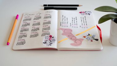 Günlük yaşam biçimi, Bullet Journal - Planer - Notebook - beyaz arkaplan, kalemler, yapışkan notlar üzerine düzenlenmiş çatal bıçaklar ile üst görünüm