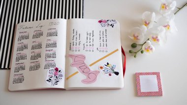 Karlsruhe, Almanya - 11,11.2019: Günlük yaşam tarzı, Bullet Journal - Planer - Notebook - Çapraz üst görünüm orkideyle izole edilmiş