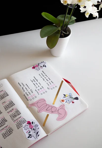 Karlsruhe, Německo - 11.11.2019: Žurnalistika, Bullet Journal - Planer - Notebook - diagonální pohled shora izolovaný na bílém pozadí s orchidejí — Stock fotografie