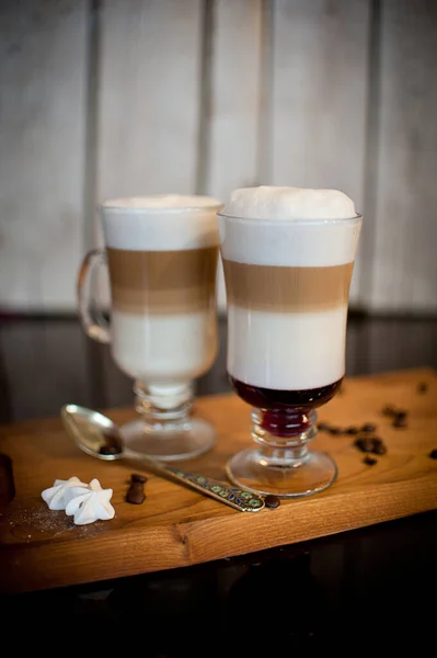 Cappuccino Lagen Twee Kopjes Een Houten Statief Een Donkere Tafel — Stockfoto