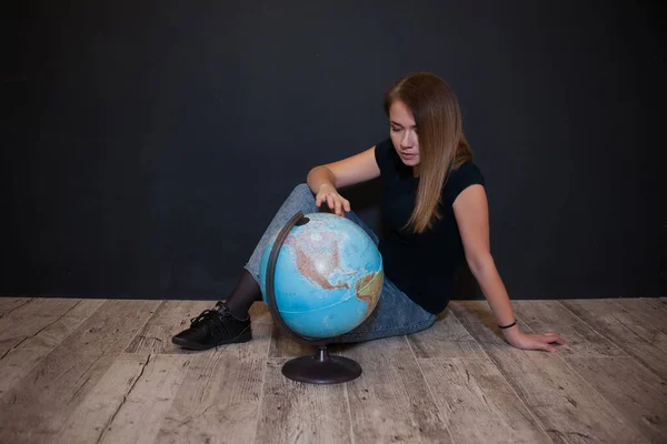 Dziewczyna Shirt Dżinsy Patrzy Globus Ciemnym Tle — Zdjęcie stockowe