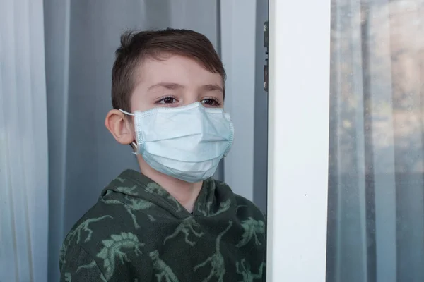 Niño Con Una Máscara Médica Ventana Casa Cuarentena Pandemia Coronavirus —  Fotos de Stock