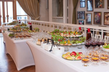 Kurumsal bir Noel ya da düğün kutlaması için çeşitli atıştırmalıklar ve aperatiflerle güzel tasarlanmış bir yemek masası.