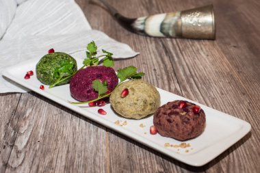 Beyaz bir tabakta ıspanak, fasulye, pancar ve fındık ile doldurulmuş bir Phali. Ahşap arka plan. Metin için boşluk