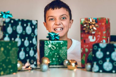 Genç çocuk Noel için hediyeler hazırlıyor. Hediyeleri masaya boşaltıyorum. Kış tatili konsepti.