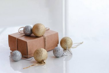 İple sarılı kağıt hediye kutusu ve beyaz arka planda izole edilmiş Noel süslemeleri. Hediyeler ve tatil konsepti.