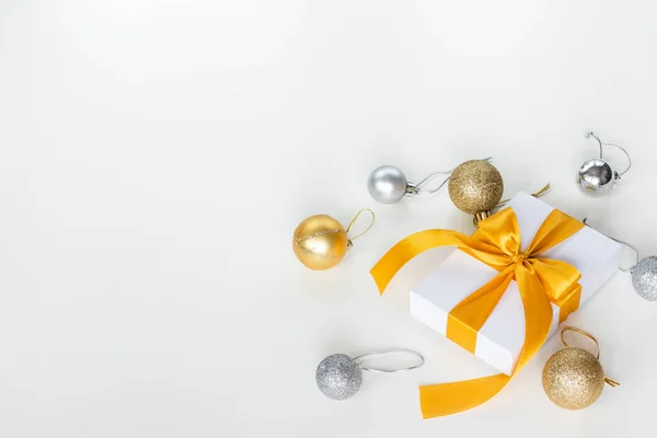 Papier geschenkdoos verpakt met geel lint met kerstversiering, geïsoleerd op witte achtergrond. Presentatie en vakantie concept. — Stockfoto