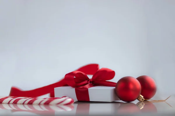 Bílá dárková krabice s červenou stuhou sladkosti a dekorace na bílém pozadí. Vánoce a Silvestrovské prázdniny koncept. — Stock fotografie